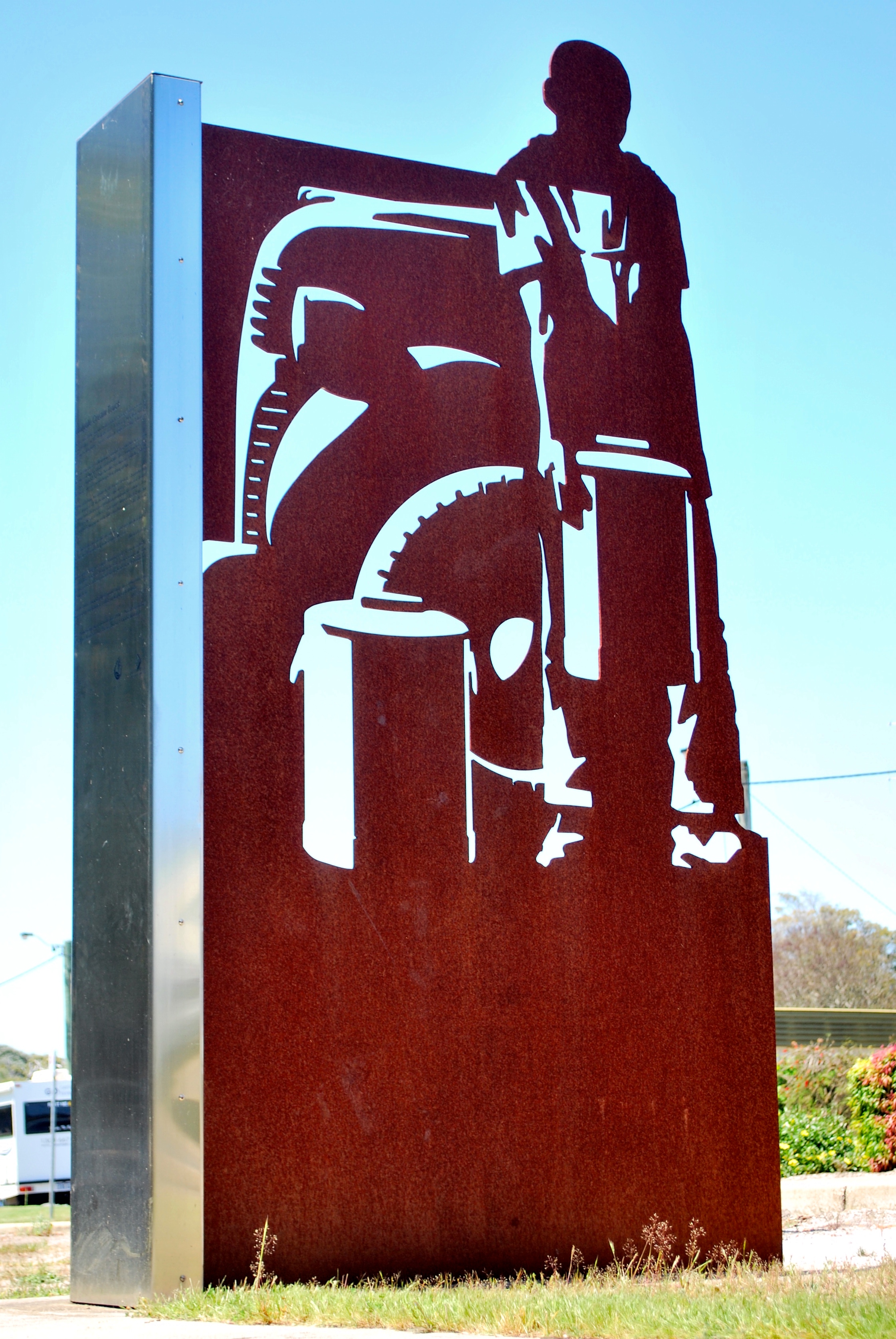 Metal sculture depicting worker with cream tins
