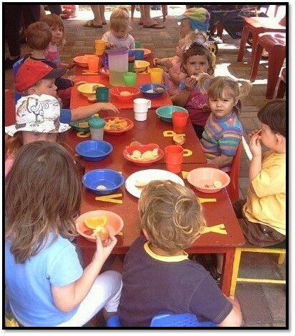 young children around a table eating
