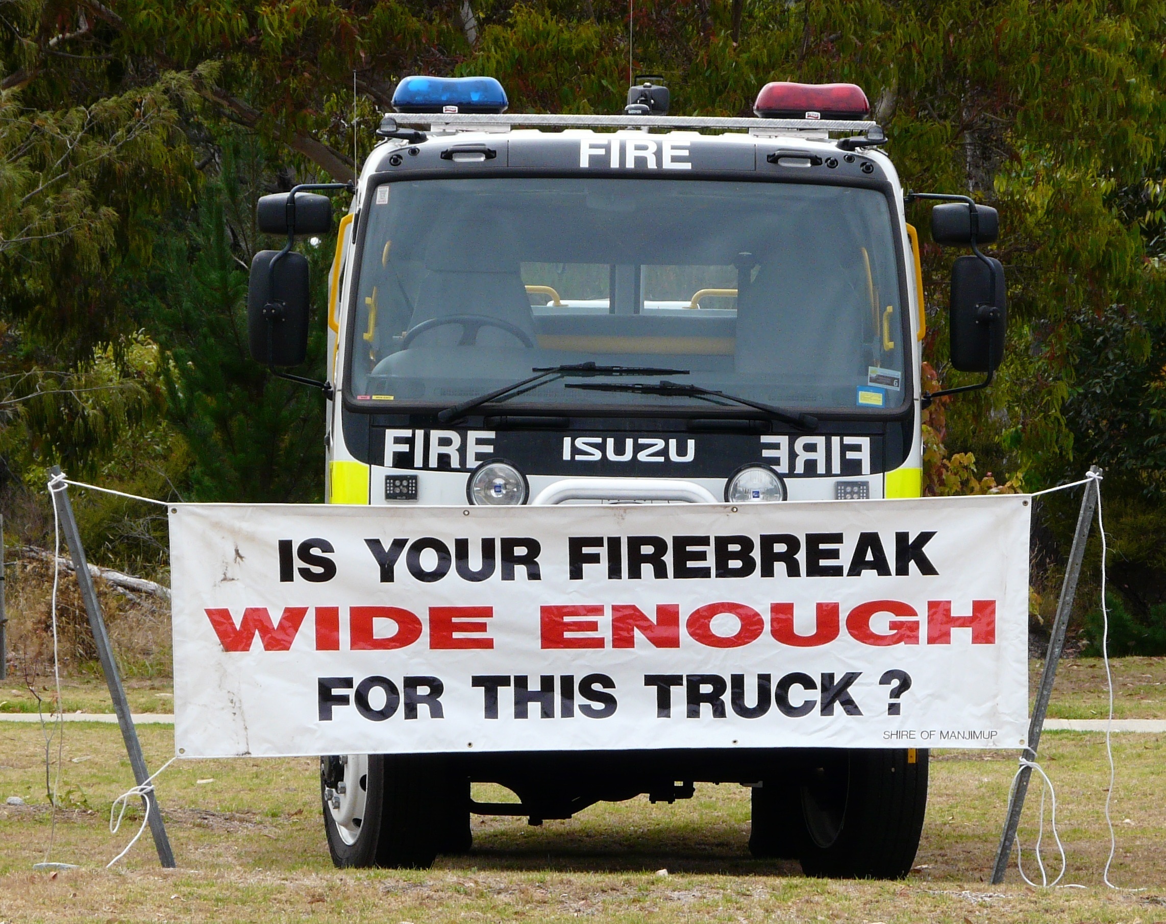 Fire truck with banner showing required width of firebreak.