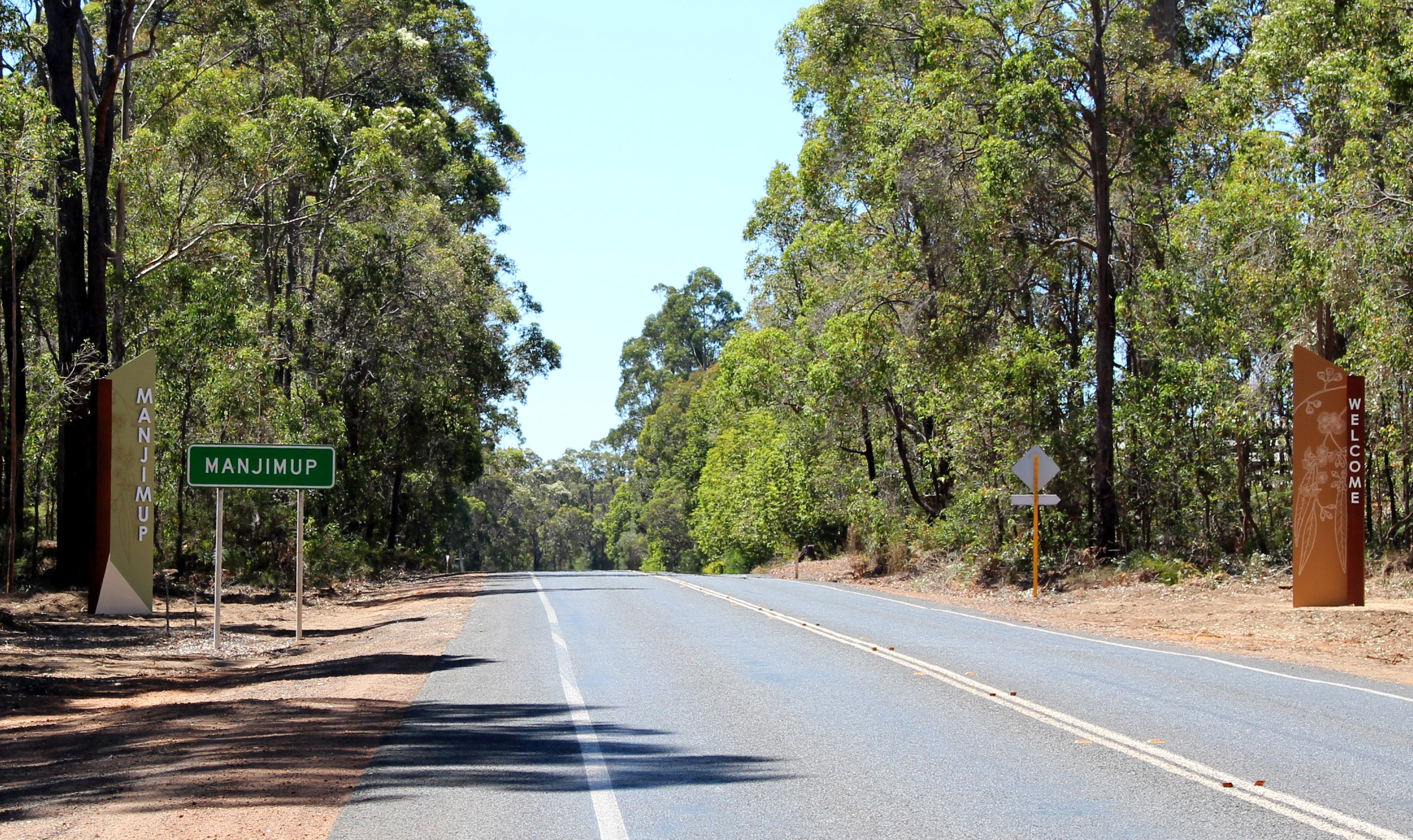Two stone work and timber pillars on roadside marking entrance to Manjimup from South.