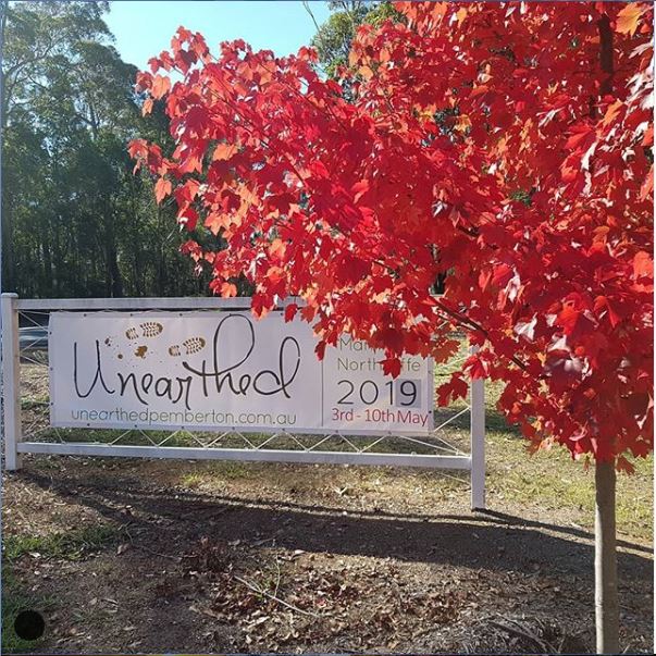 event banner on frame near red autum tree