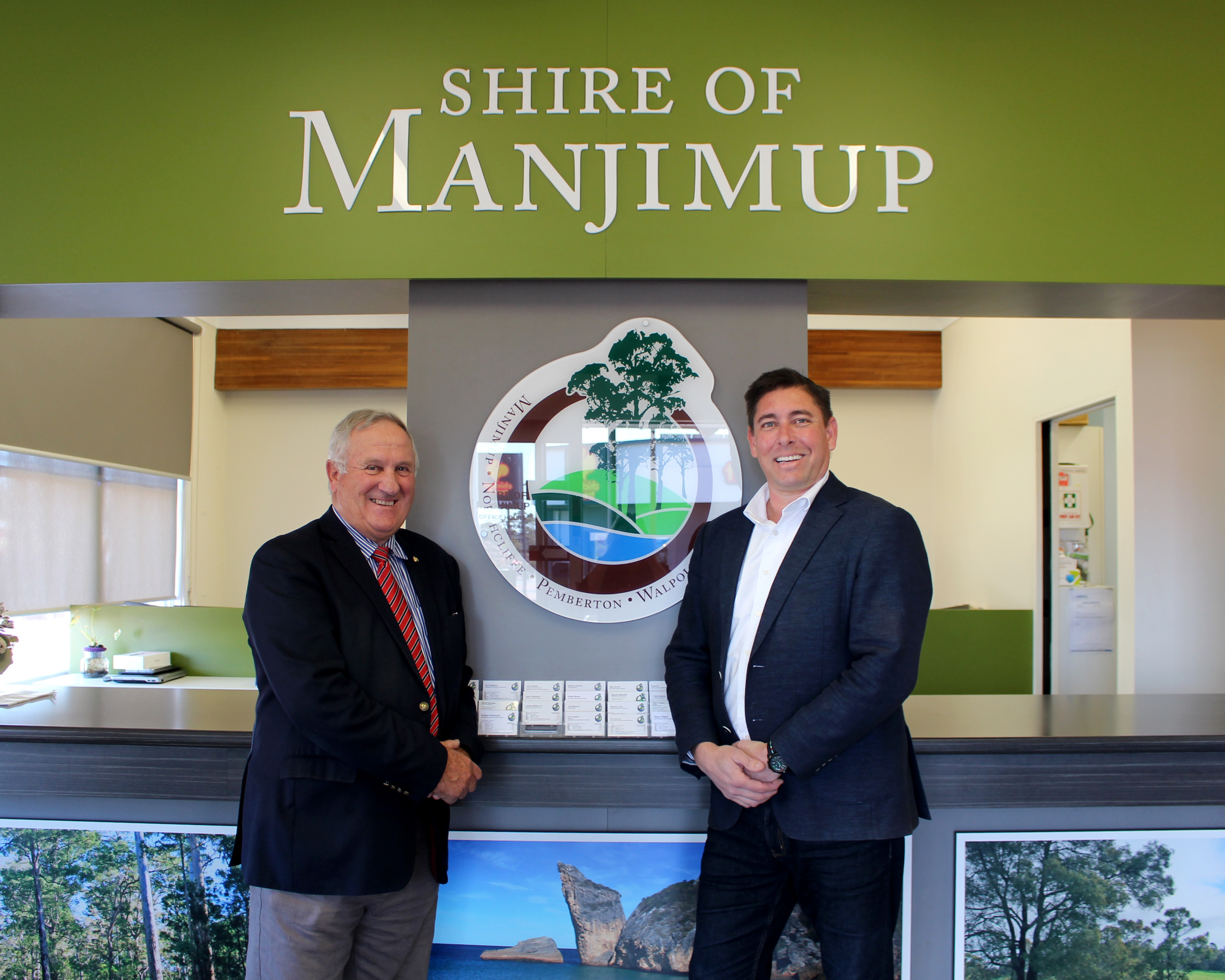 Shire President Paul Omodei and incoming New Chief Executive Officer Ben Rose under the Shire of Manjimup logo in the Shire Administration Building